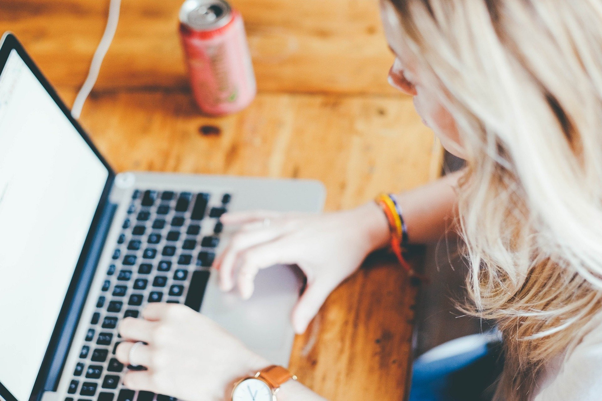 Woman sitting in front of a laptop and writing. 